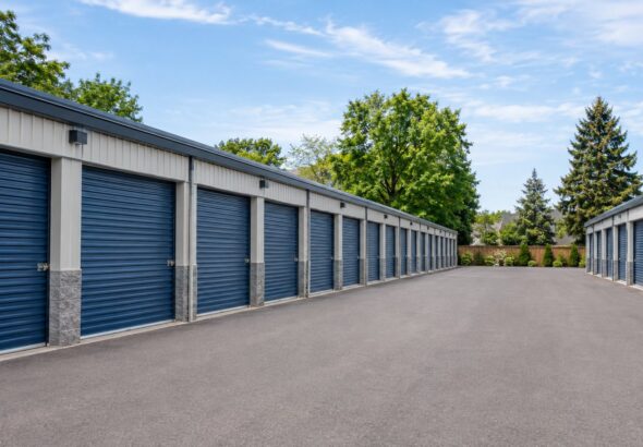 Rows of outdoor self-storage units surrounding a paved drive